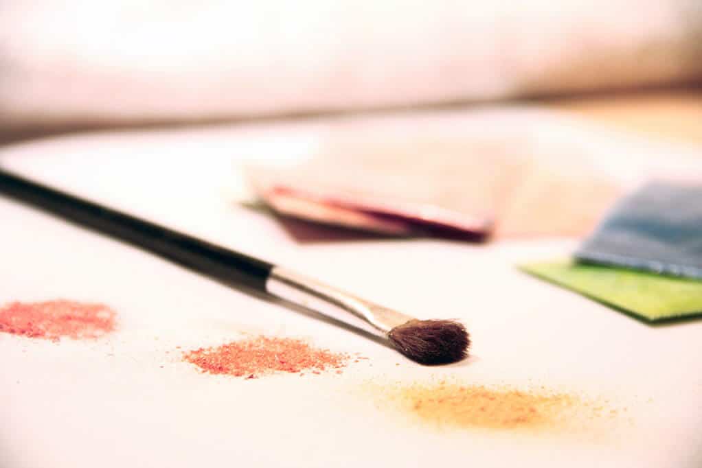 RGBA opacity. an artists brush sits on a white paper next to small piles of dry pigment