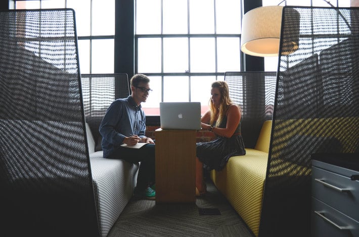 two people look at a computer 