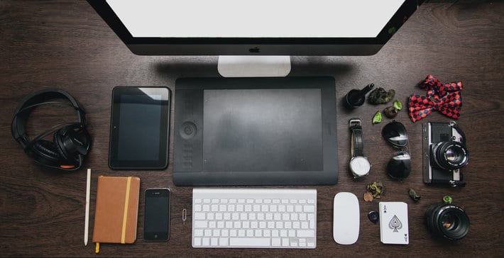 desktop computer with keyboard, mouse, headphones, phone, panner, camera