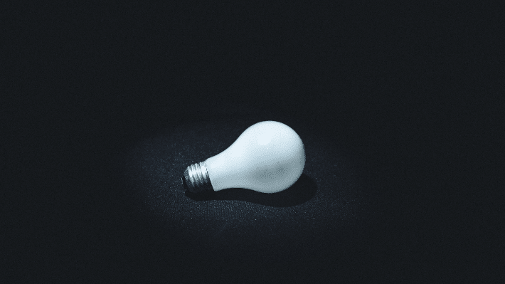 How to Improve Your WordPress Site Speed and Performance. Image depicts a lightbulb on a black background