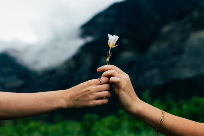 Someone handing a flower to someone else