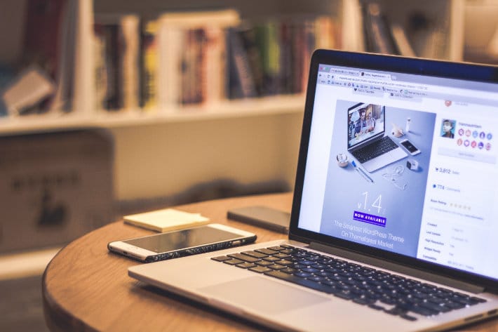 a laptop sits on a wooden end table