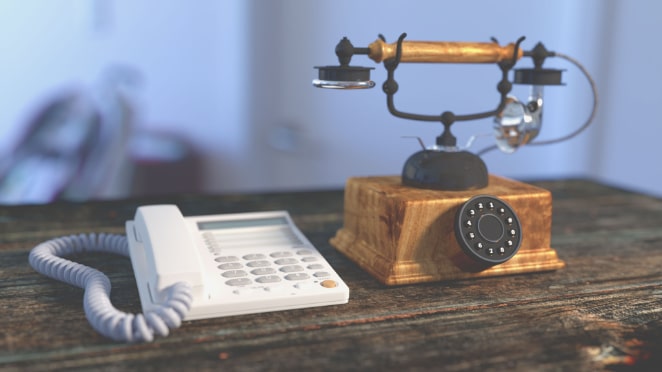 On older gold telephone next to a newer white one