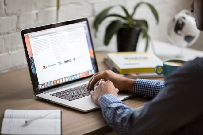 a person sits at a desk in front of a laptop