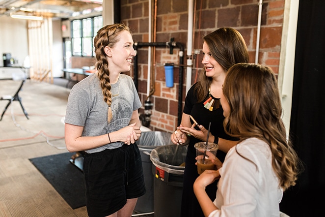 three women speaking and laughing