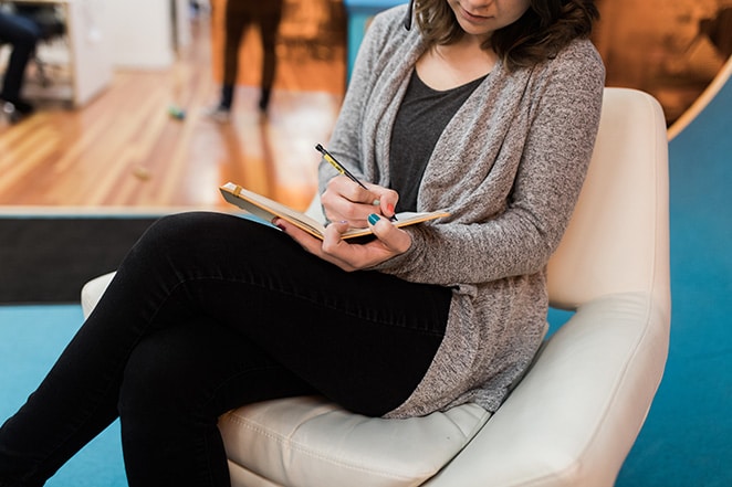 woman writing in notebook report