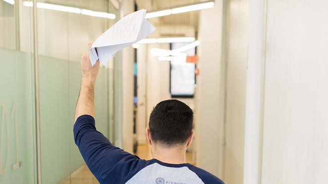 man holding up a stack of papers