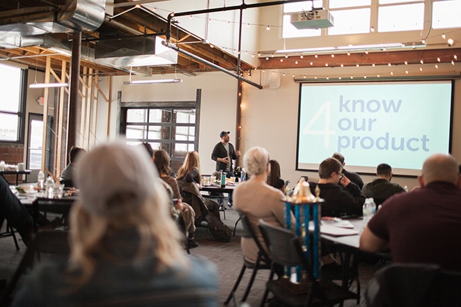 man presenting to crowd on knowing products