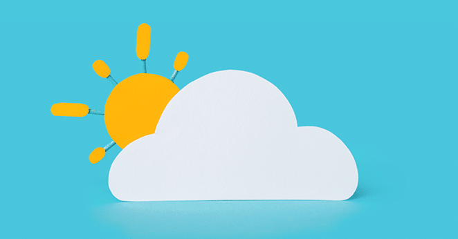 paper cloud with sun peeking out behind it on bright blue background