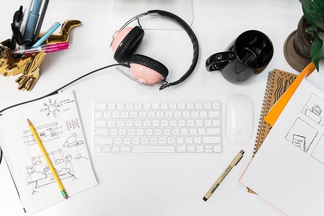 design patterns keyboard and mouse with paper pen pencil and sketches on white desk