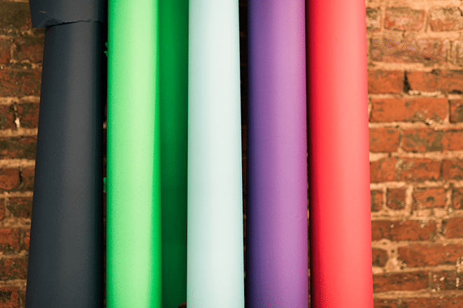 five colored backdrops leaning against brick wall